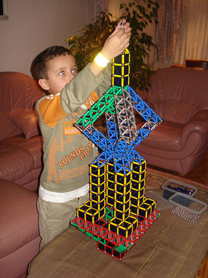 Ребенок собирает башню из Geomag